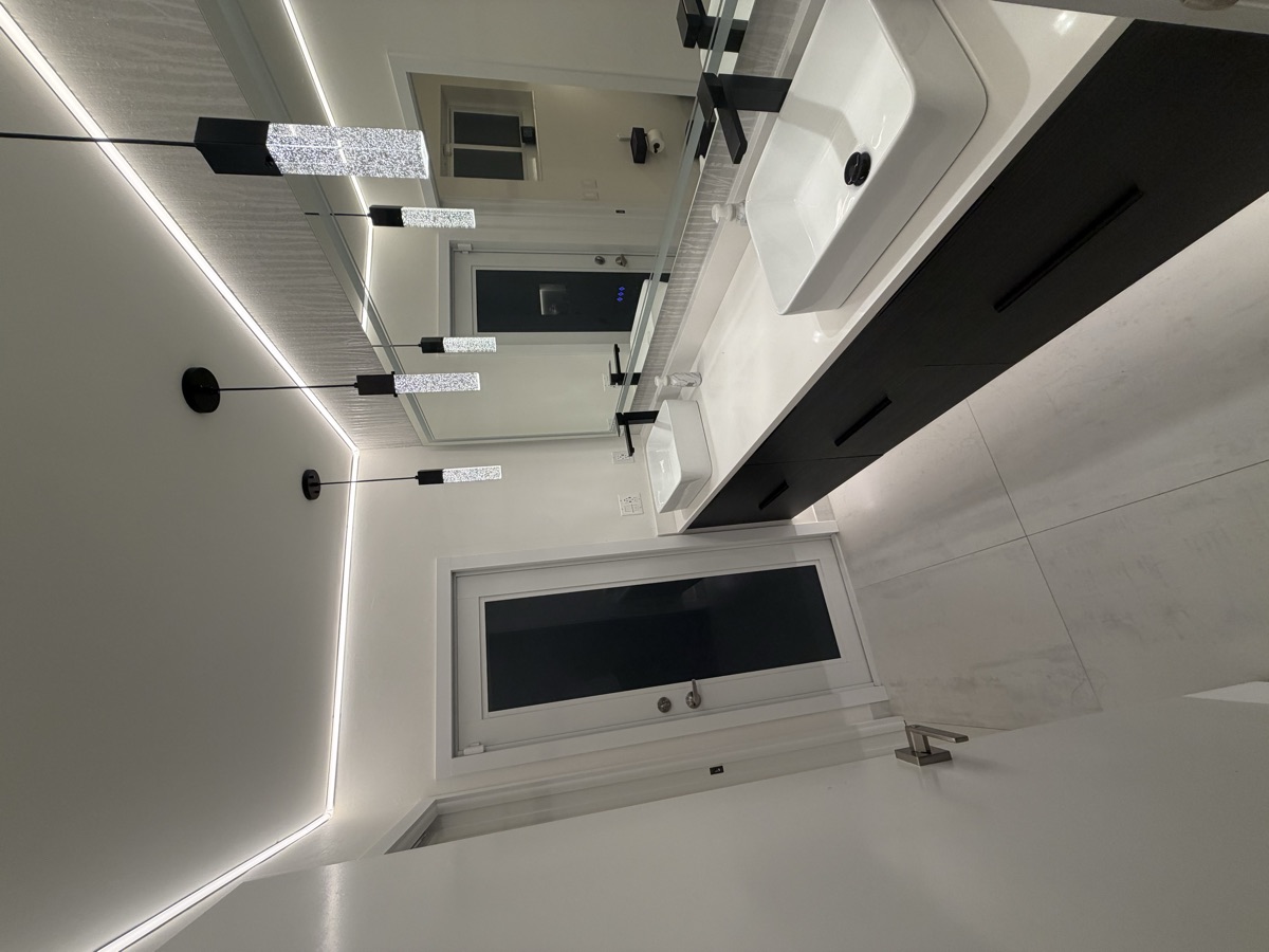 Black double vanity with vessel sinks and LED ceiling lights